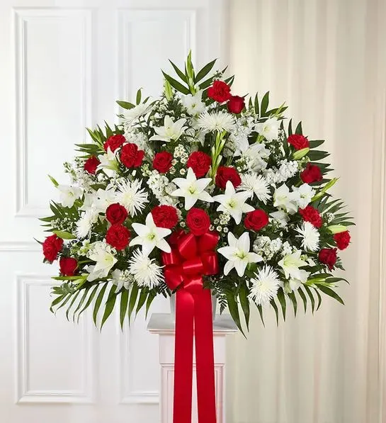 Standing Basket- Red &amp; White - Love can help keep us going after a difficult loss. Sometimes this emotion is best expressed through a beautiful floral statement. Crafted by our expert florists, this traditional standing basket arrangement is filled with an array of red and white blooms, offering heartfelt condolences when words alone aren’t enough.