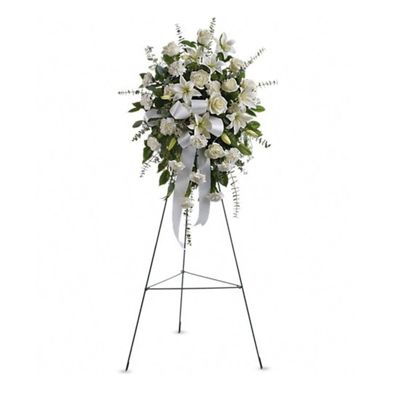 Sentiments of Serenity Spray - Beautifully simple this lovely spray of white roses lilies and carnations decorated with white satin ribbon is a tasteful way to express your sympathy. The elegant spray includes white roses white Asiatic lilies and white carnations accented with assorted greenery.  Approximately 25&quot; W x 35 1/2&quot; H Orientation: One-Sided