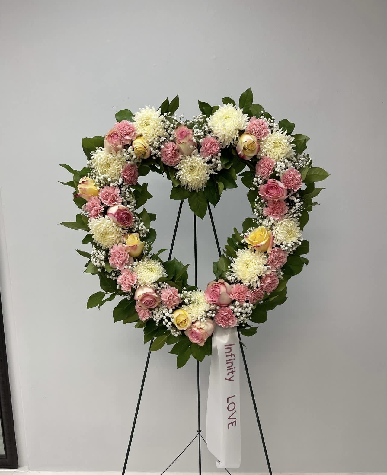 Open Heart Standing Spray Open Heart Standing Spray - A mixture of white, yellow and pink flowers.