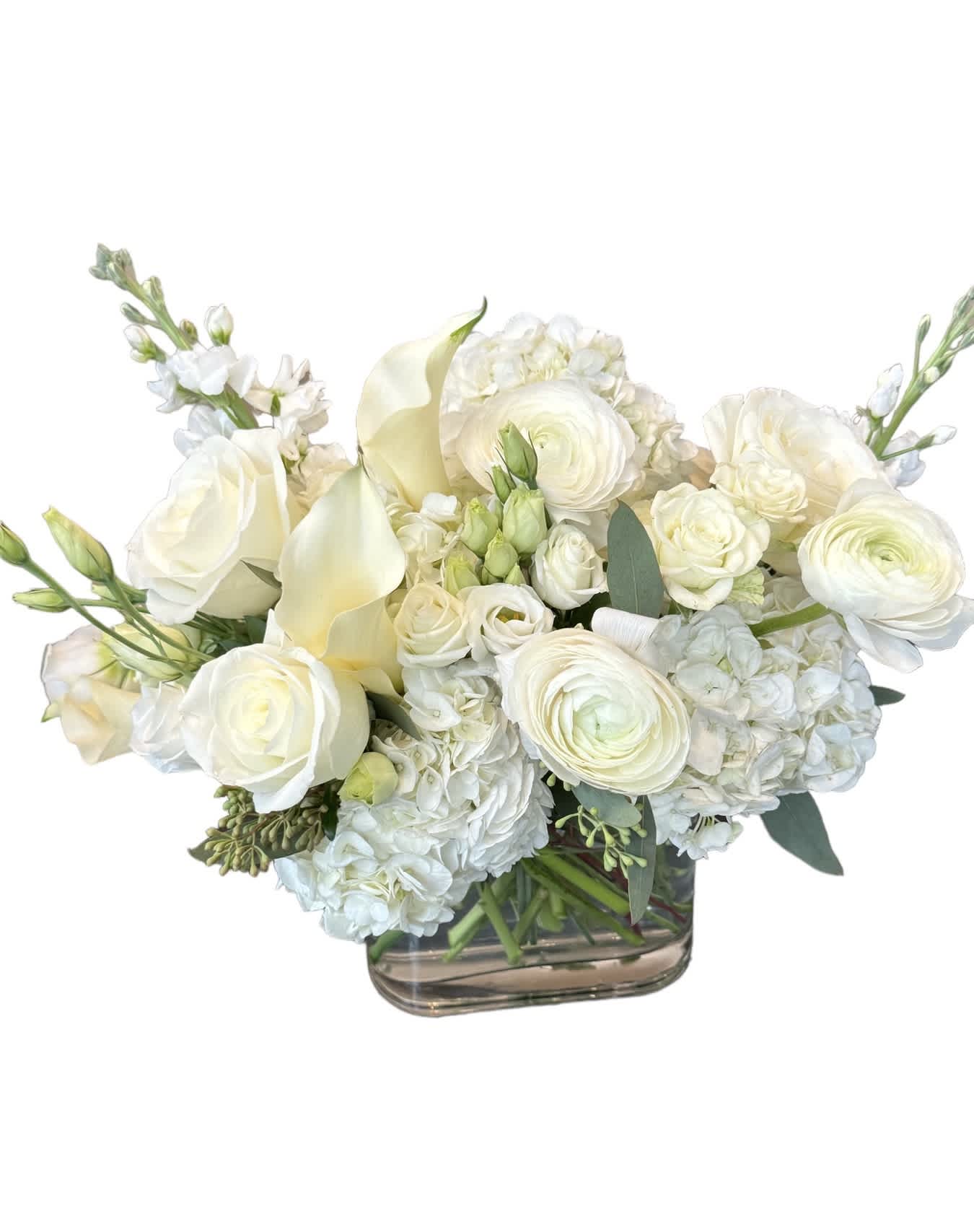 All White Wedding Centerpiece  - White ranunculus, white calla lily, white hydrangea, white rose, white spray rose, white lisianthus and eucalyptus designed in a glass vase.