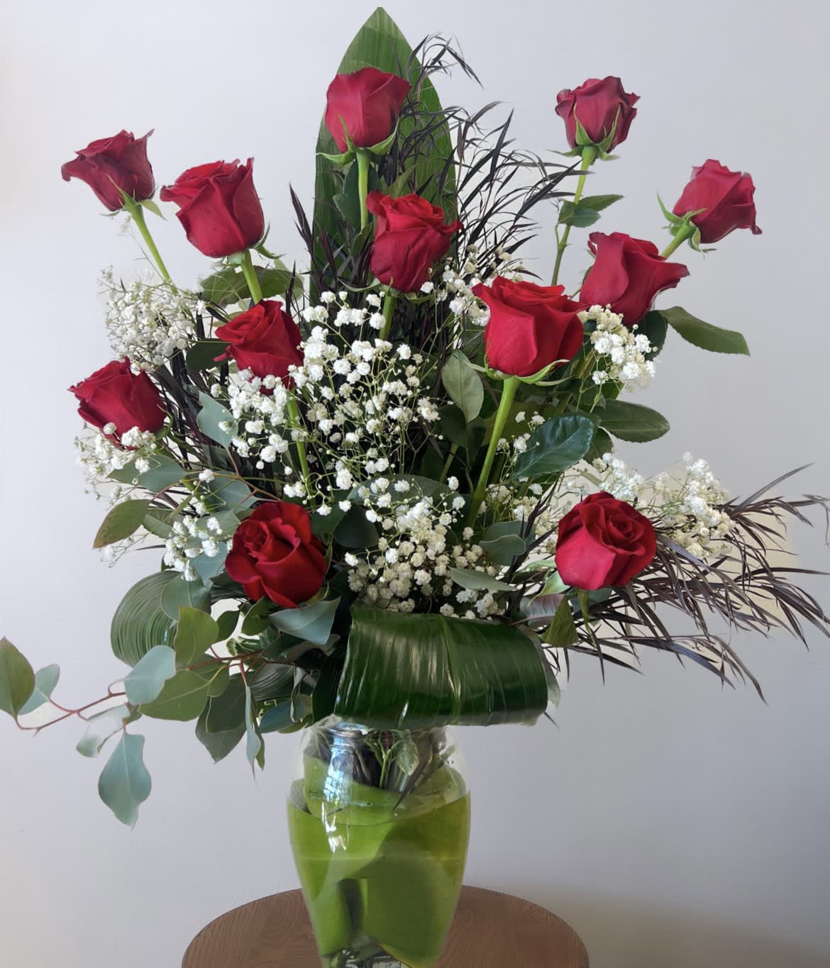 Forever and Always: Glamorous Dozen Red Roses - Dozen red roses arranged front facing with modern filler and greenery. 