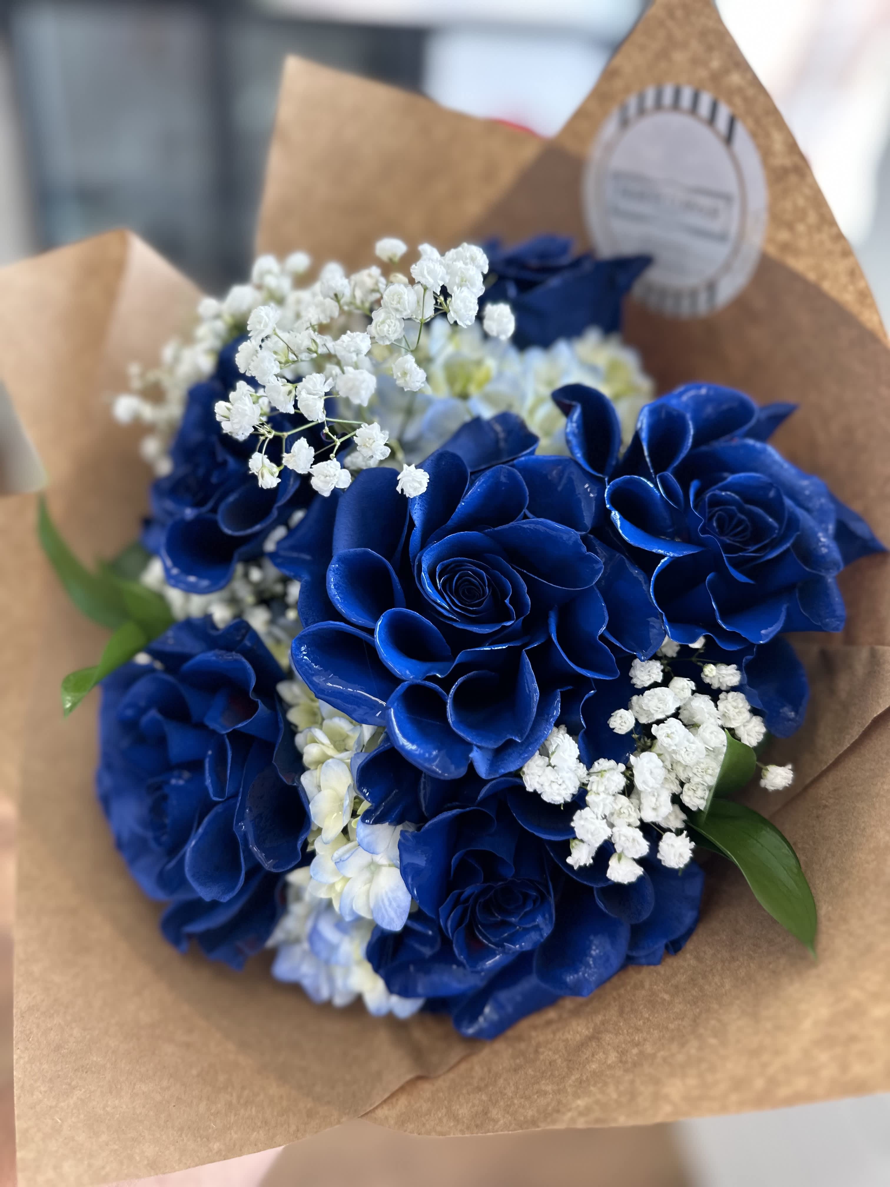 Blue Rose Bouquet - Introducing Blue Rose Bouquet, a half dozen arrangement featuring blue hydrangeas and baby's breath, elegantly wrapped in paper.  Experience the enchantment of &quot;Blue Rose&quot; with its unique combination of flowers. Order now to add a touch of elegance to any occasion with this beautiful bouquet.
