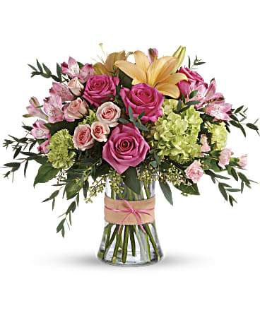 Blush Life Bouquet - Go ahead, make them blush! This luxurious bouquet of roses, lilies and hydrangea in fresh shades of pink, peach and green is sure to put some cheerful color in their cheeks! The delicate ribbons dress up the graceful keepsake vase.  DGTEV56-3B