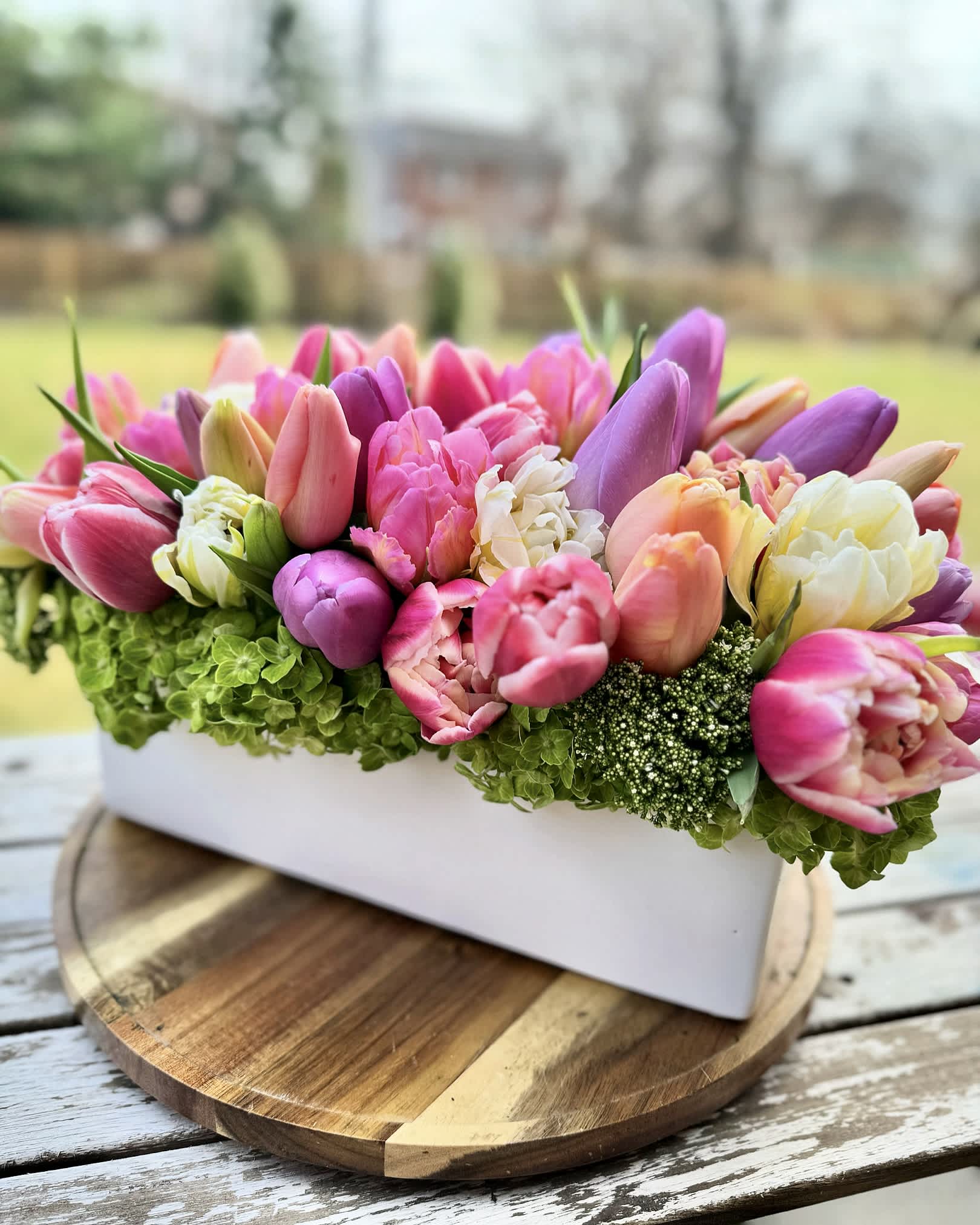 Tulip Field - A beautiful assortment of single and double tulip in a rainbow mix of bright colors. Arranged in a long container.