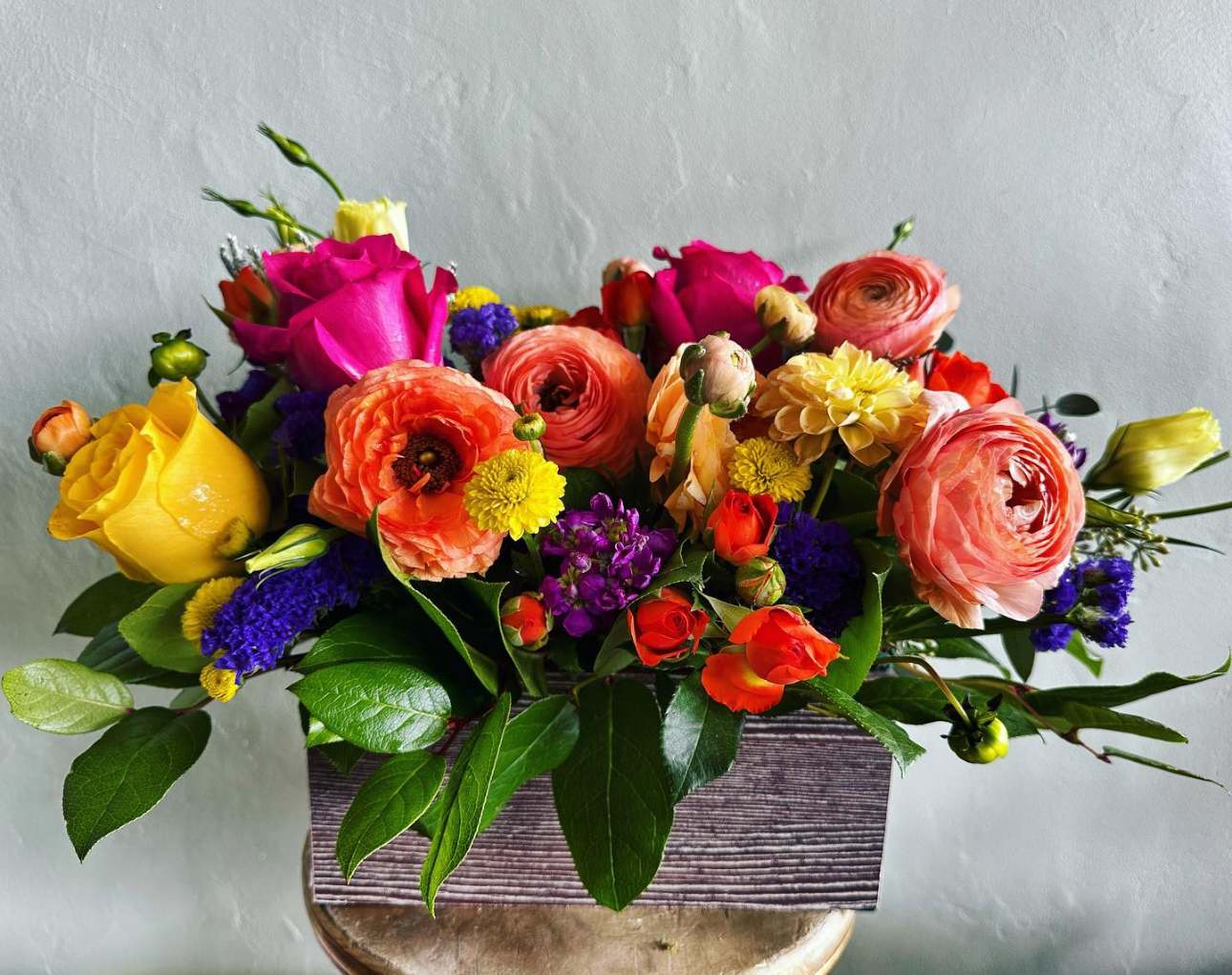 Groovy Groovy - Keep things fun with this jewel toned flower box! Ranunculus, roses, and lisianthus in a wooden garden box give this arrangement its bright colors and textures to create a beautiful centerpiece or gift. APPROXIMATE DIMENSIONS 18" W X 10" H