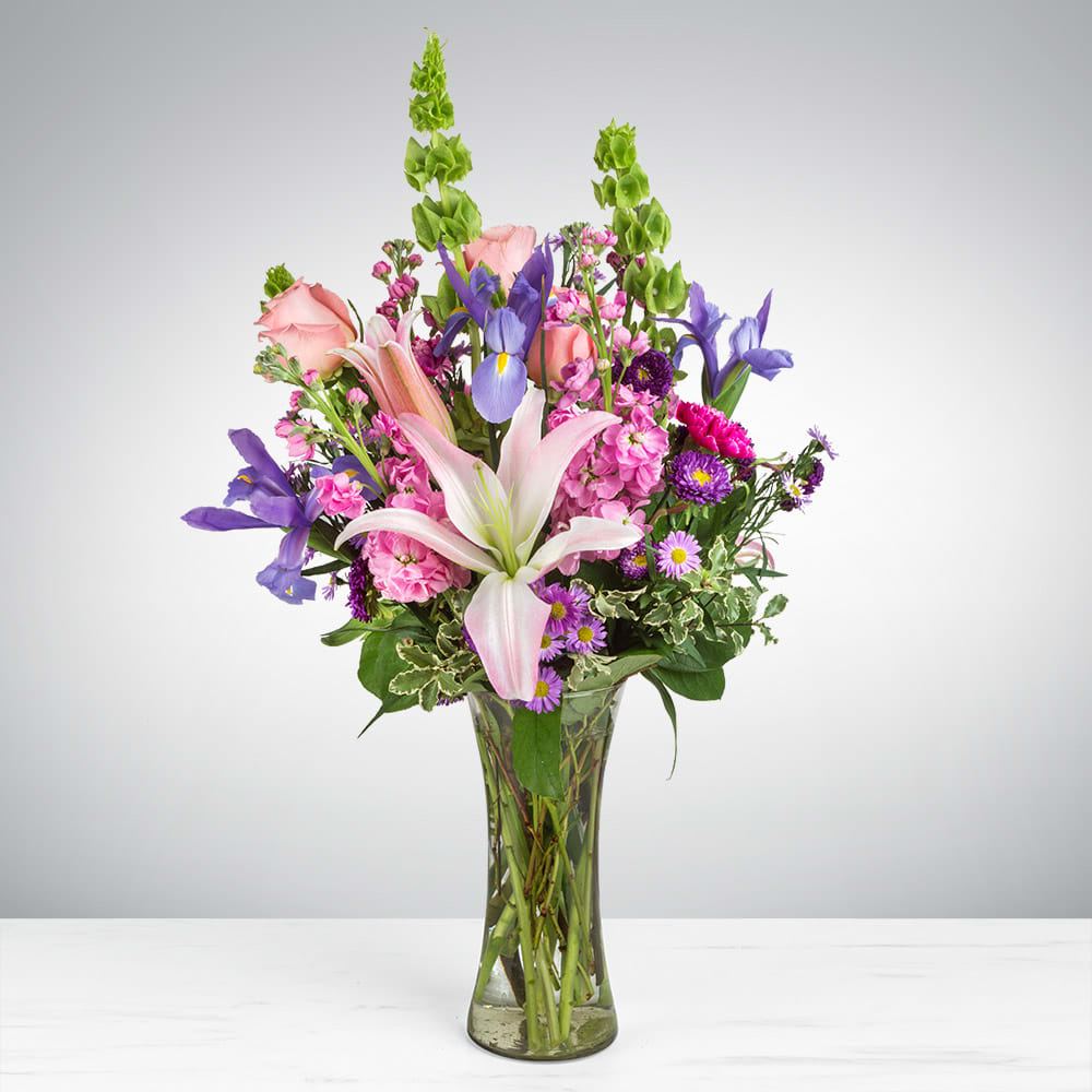 Enchanted Fairytale - This arrangement contains stargazer lilies, bells of ireland, stock, blue iris, roses, carnations, and purple aster. This is a great gift for birthday, Mother's Day, love and romance, or to say thank you. APPROXIMATE DIMENSIONS: 16&quot; D x 26&quot; H
