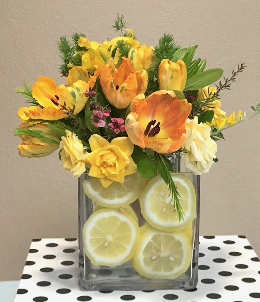 Lemon-Aid Cheer - This cheerful bouquet of yellow and orange flowers features tulips (seasonal), mini spray roses, and a slice or two of lemons for a great pick-me-up.
