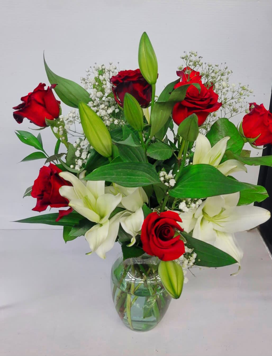 Glass vase #4 - it is made with: 2 white lilies 7 red roses 2 baby breath greens 