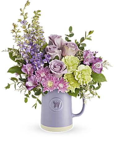 Sweetest Pastel Flutter - Lavender glazed stoneware pitcher, food safe, embossed with a butterfly filled with roses, alstroemeria, mums, carnations, larkspur, and mixed greens.