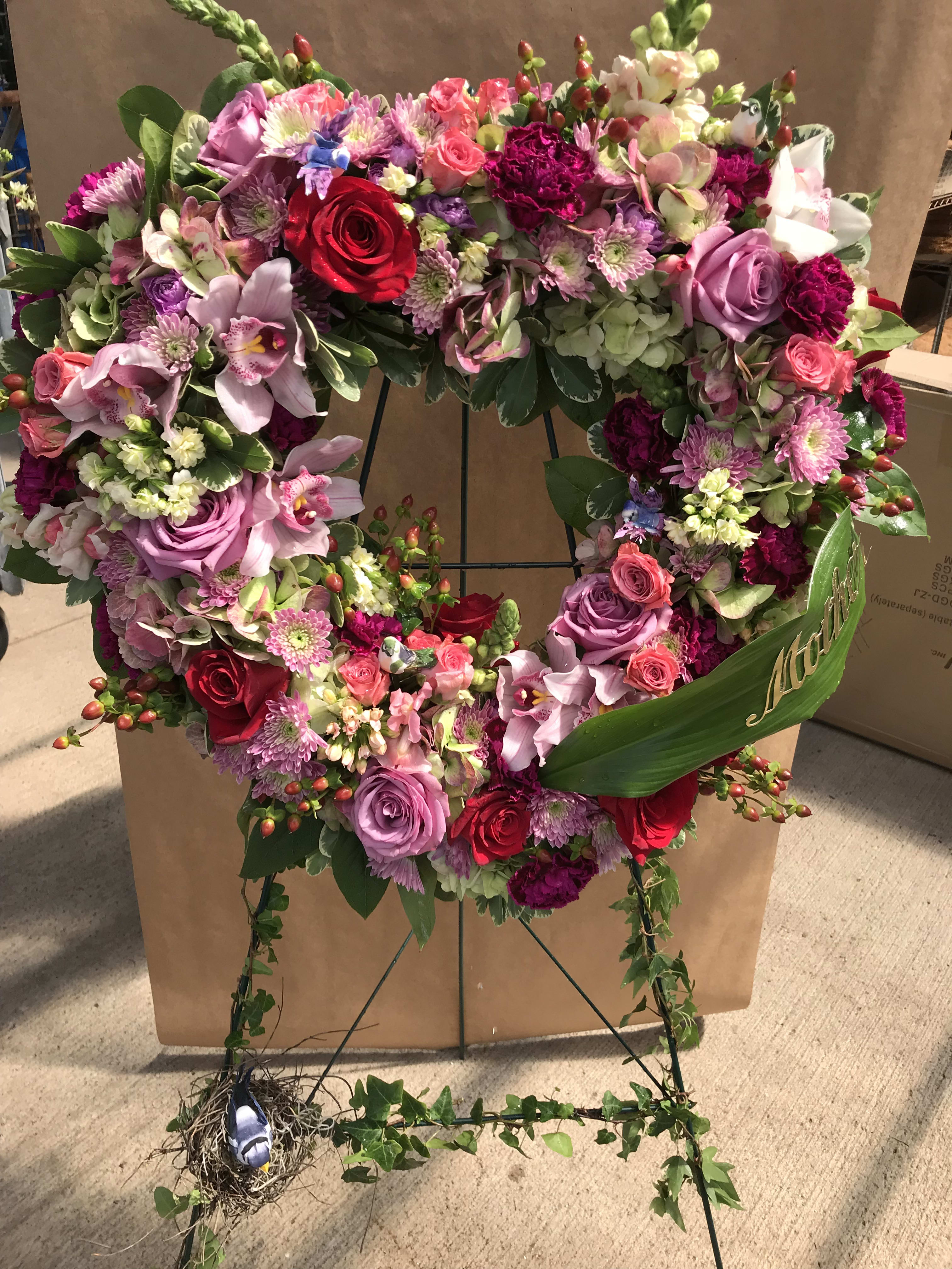 Elegant Heart Shaped Standing Spray - Our artisan handmade arrangement's overall theme is different shades of pink. The actual bouquet or arrangement may not precisely match the photo,but its temperament will. The freshest, artisan flowers available are used to create an exquisite arrangement especially for you. We also use a variety of unusual greenery for an example eucalyptus, salal (lemon leaf), pittisporum. Occasionally, substitutions of flowers or containers happen due to weather, seasonality and market conditions which may affect availability. If this is the case with the gift you've selected,we will ensure that the style, theme and color scheme of your arrangement is preserved and will only substitute items of equal or higher value.
