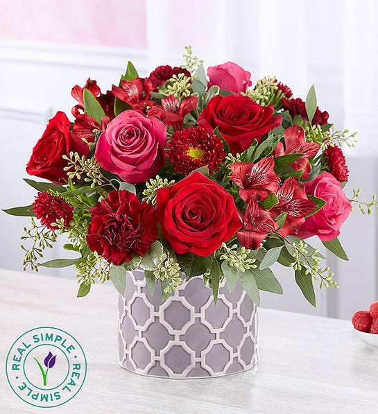 Forever Yours by Real Simple® - EXCLUSIVE Capture a love that’s forever with a gift they’ll always remember. Designed exclusively through our partnership with Real Simple®, this striking medley of blooms brings together a rich blend of color and texture. Adding a chic, modern look is our geometric cylinder vase. With clean lines that highlight each bloom, this romantic surprise is a stylish expression of your affection.  All-around arrangement with red roses, Matsumoto asters and Peruvian lilies (alstroemeria), hot pink roses, burgundy carnations; accented with assorted greenery Artistically designed in our exclusive keepsake geometric cylinder vase; a modern grey &amp; white ceramic design featuring an embossed pattern, which can be repurposed over time as a planter or to store essentials; measures 6&quot;W x 4.5&quot;H Arrangement measures approximately 11&quot;H x 10&quot;W Our florists select the freshest flowers available, so colors and varieties may vary due to local availability To ensure lasting beauty, lilies may arrive in bud form, and will fully bloom over the next few days 