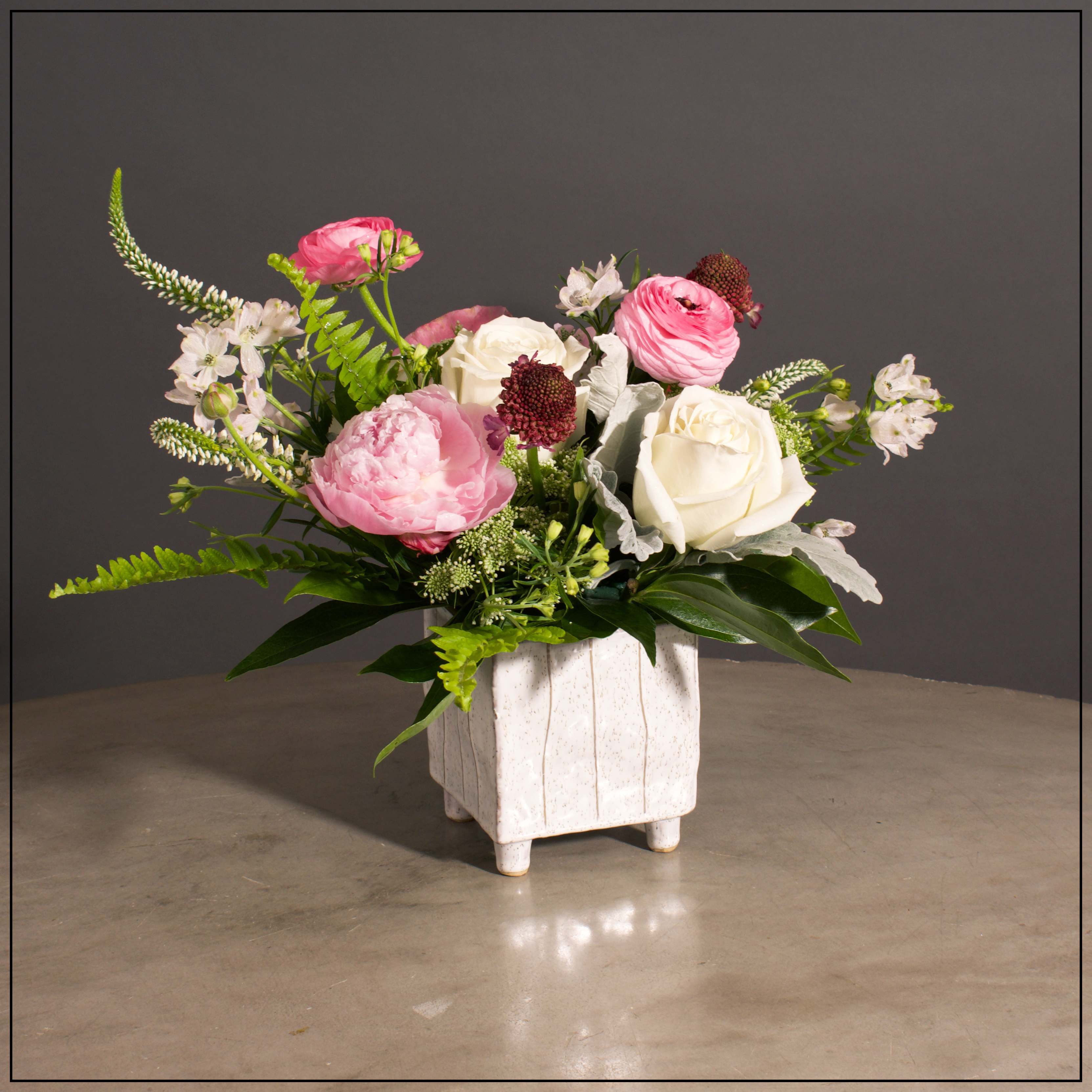 Peyton - Peonies, Roses, Veronica and Scabiosa with Mixed Greens in a White Footed Square Container.  Approximately 13&quot; H x 17&quot; W