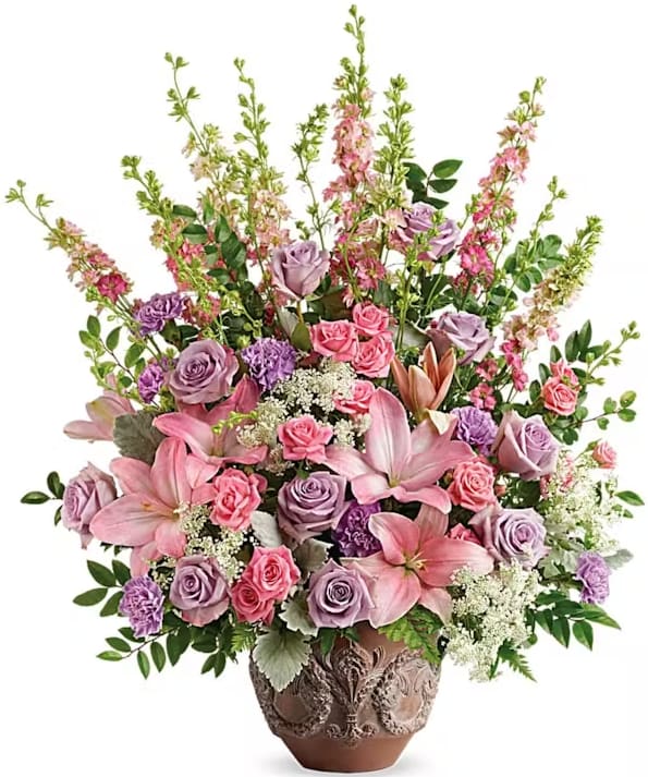 Early Spring Early Spring - Like a whisper from heaven, the soft pinks and lavenders in this feminine arrangement bring peace and hope in a time of loss. Presented in a large antiqued pot, it's a loving tribute all will appreciate. This soft pink arrangement features lavender roses, pink spray roses, pink asiatic lilies, lavender carnations, pink larkspur, queen anne's lace, huckleberry, dusty miller, and leatherleaf fern.