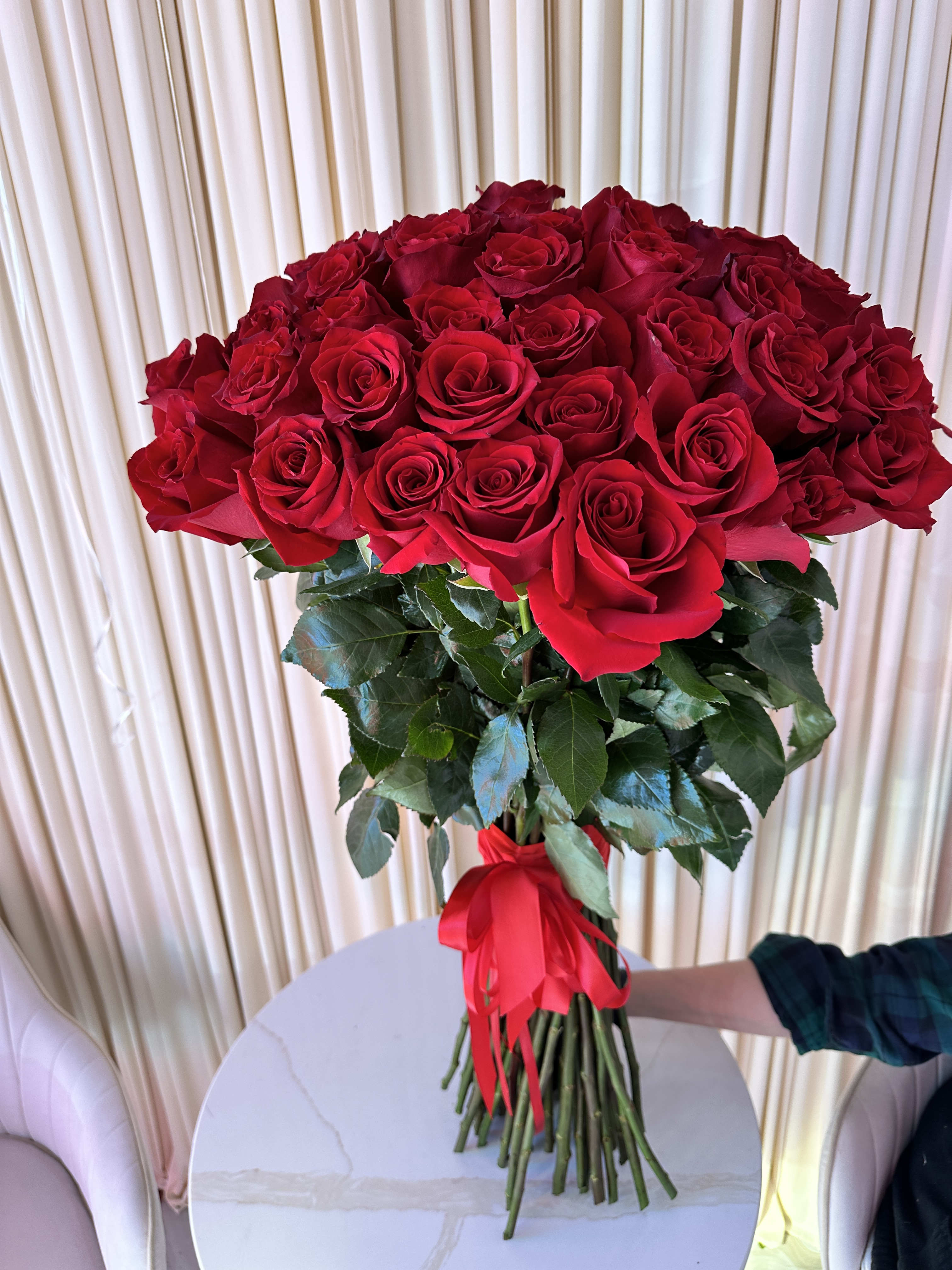 Scarlet Symphony  - Celebrate love's symphony with this breathtaking bouquet of 50 radiant red roses. The fiery color and velvety texture of the blooms create a truly unforgettable arrangement.