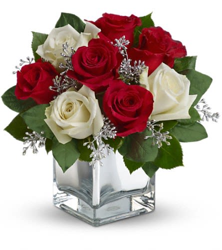 Teleflora's Snowy Night Bouquet - The perfect Christmas hostess gift this exciting bouquet of red and white roses in a dazzling mirrored cube is guaranteed to make spirits brighter. Simple stylish affordable ?- better order one for yourself as well. The delightful holiday bouquet features red roses and white roses accented with assorted greenery.Approximately 11&quot; W x 10 3/4&quot; H Orientation: All-Around As Shown : T407-2ADeluxe : T407-2BPremium : T407-2C