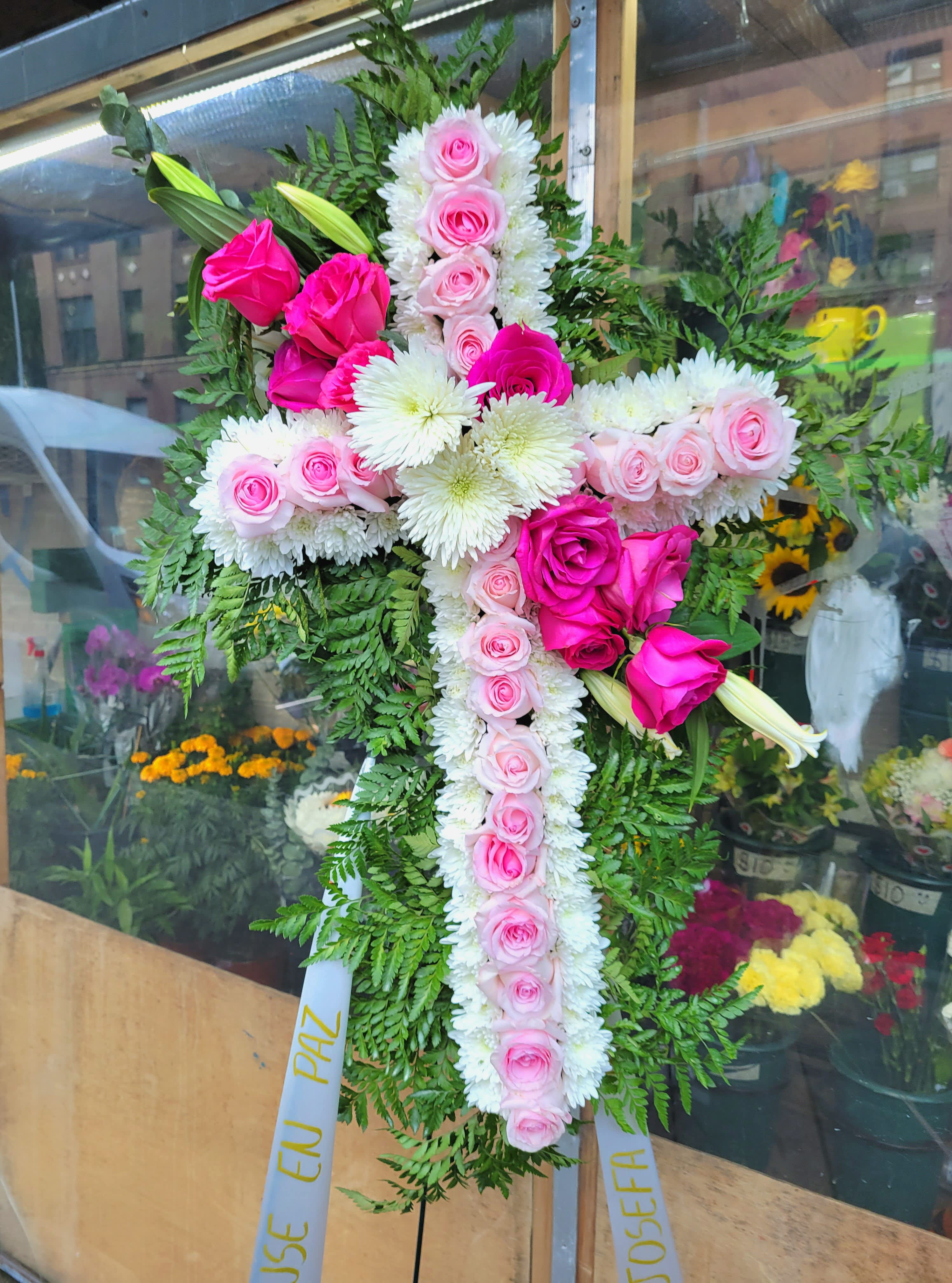 Standing cross #3 Standing cross #3 - it is made with: 9 hot pink roses 22 light pink roses 3 white mums/spiders white pompom 2 white lilies greens stand.