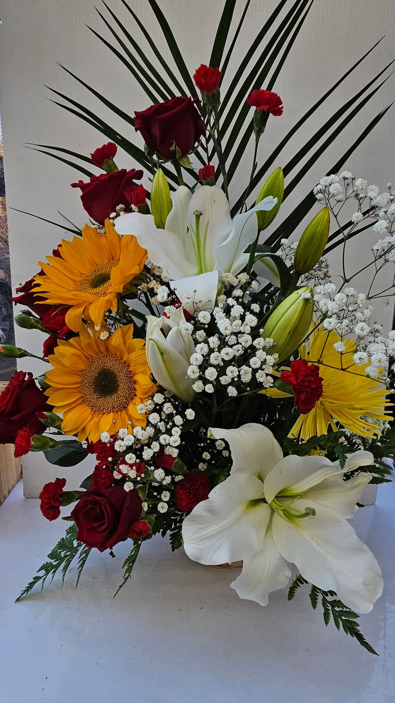 Half red moon in basket 2.0 Half red moon in basket 2.0 - it is made with: 6 red roses 2 sunflowes 6 red mini carnation 2 baby breath 2 white lilies 1 yellow spiders greens basket.
