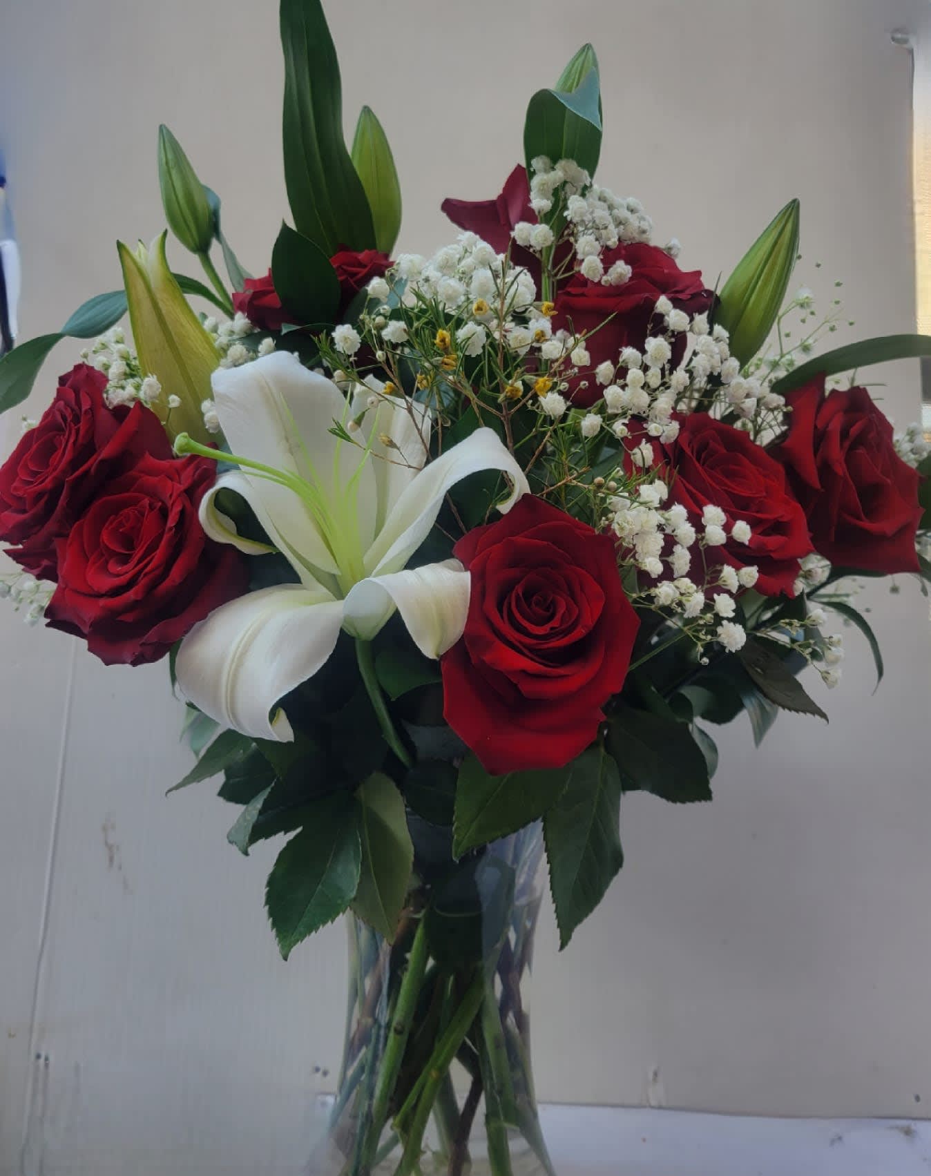 Glass vase #8 - it is made with: 2 white lilies 12 red roses 3 baby breath greens glass vase