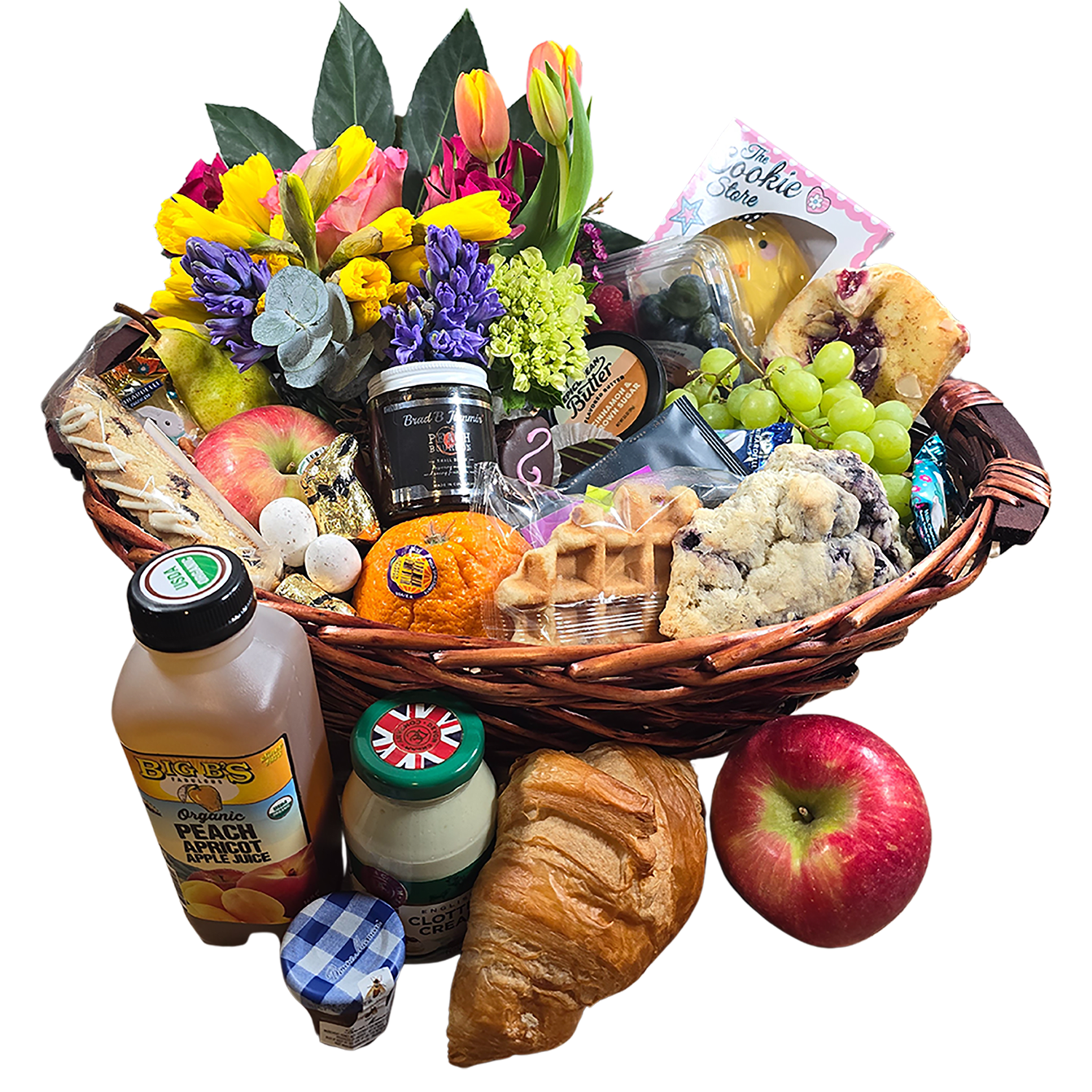 Spring Splendor Brunch Basket: Gourmet Delights & Blossoms Galore Spring Splendor Brunch Basket: Gourmet Delights & Blossoms Galore - Embrace the essence of spring with our Grand Spring Brunch Gift Basket, a lavish assortment of gourmet treats, and a vibrant floral display that captures the spirit of the Easter season. This exquisitely curated basket is a feast for the senses, designed to be enjoyed with family or serve as the stunning centerpiece of your Easter festivities. Centerstage in this opulent basket is a decadent Epicurean Butter, ideal for enriching warm baked goods or enhancing the natural flavors of fresh fruit. And speaking of fruit, this basket overflows with 15 servings of the freshest, most succulent seasonal fruits, including juicy berries and crisp orchard selections, ready to invigorate your palate. Easter is synonymous with joy and whimsy, elements brought to life by our meticulously hand-decorated Easter cookies. These artful creations are accompanied by exquisite chocolate bunnies and a colorful assortment of Easter eggs, each made from premium chocolate to add a dash of magic to your Easter celebrations. Nestled among these gastronomic delights is a large, lush spring flower arrangement. This bouquet showcases the season's freshest blooms, adding a visual feast that complements the basket’s bounty and infuses any space with the delicate fragrance of spring. The basket also includes irresistibly flaky pastries, a jar of Palisade Peach Jam bursting with natural sweetness, and a selection of teas that perfectly match the clotted cream and Colorado Juice provided. A jar of local honey is the finishing touch, ideal for sweetening your treats or tea, elevating the brunch experience to new heights. Crafted with meticulous attention to detail, each Grand Easter Brunch Gift Basket is a testament to quality and elegance, offering more than just a gift—it's an invitation to indulge, relish, and commemorate the renewal and joy that Easter and spring bring