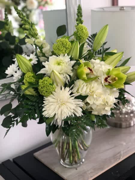 Cherish - A delicate blend green and white flowers arranged in a tall clear glass vase with mixed greenery.  