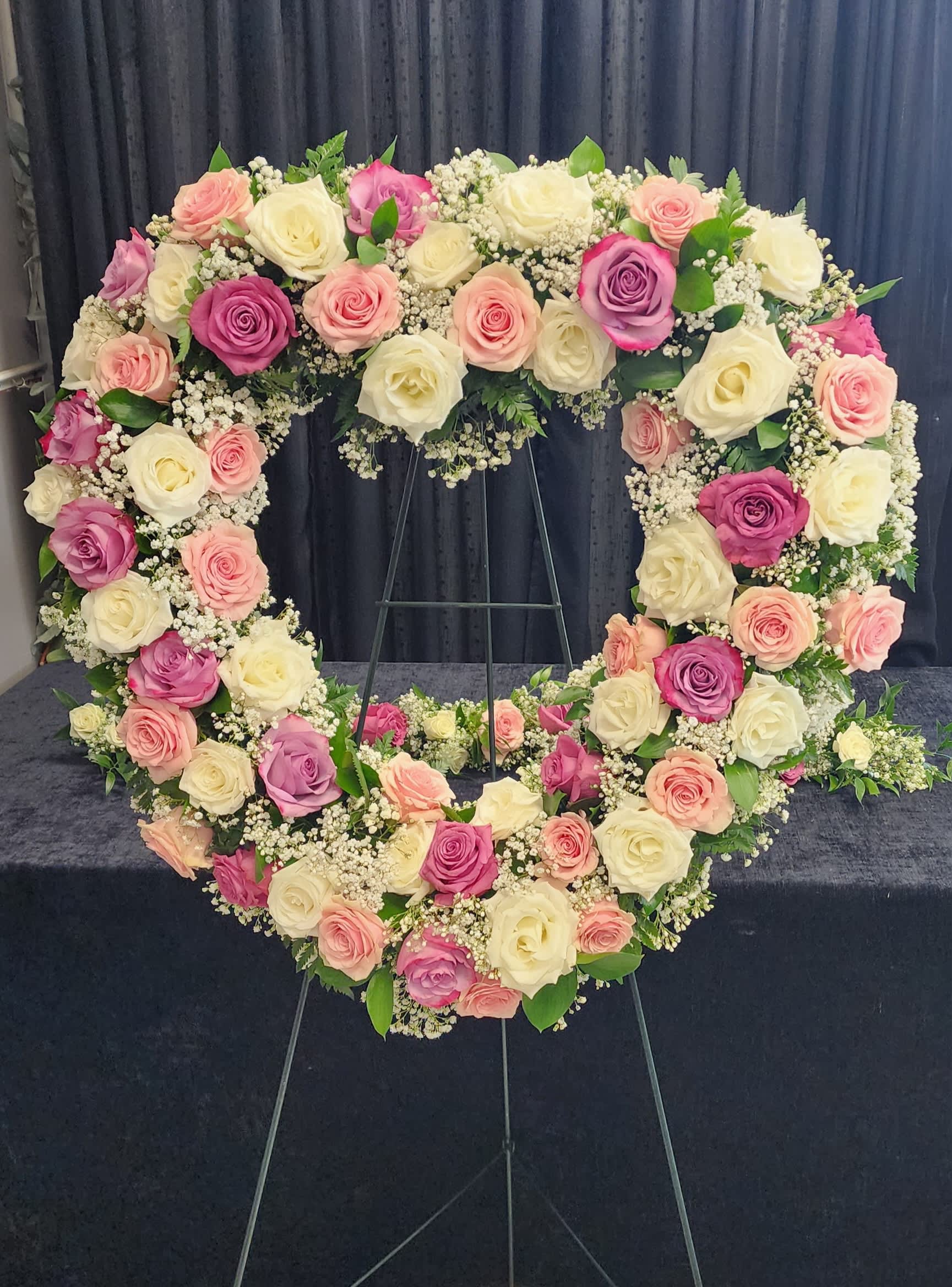 Pastel rose standing heart. Pastel rose standing heart. - A heart shaped form filled with pastel roses and filler flowers.