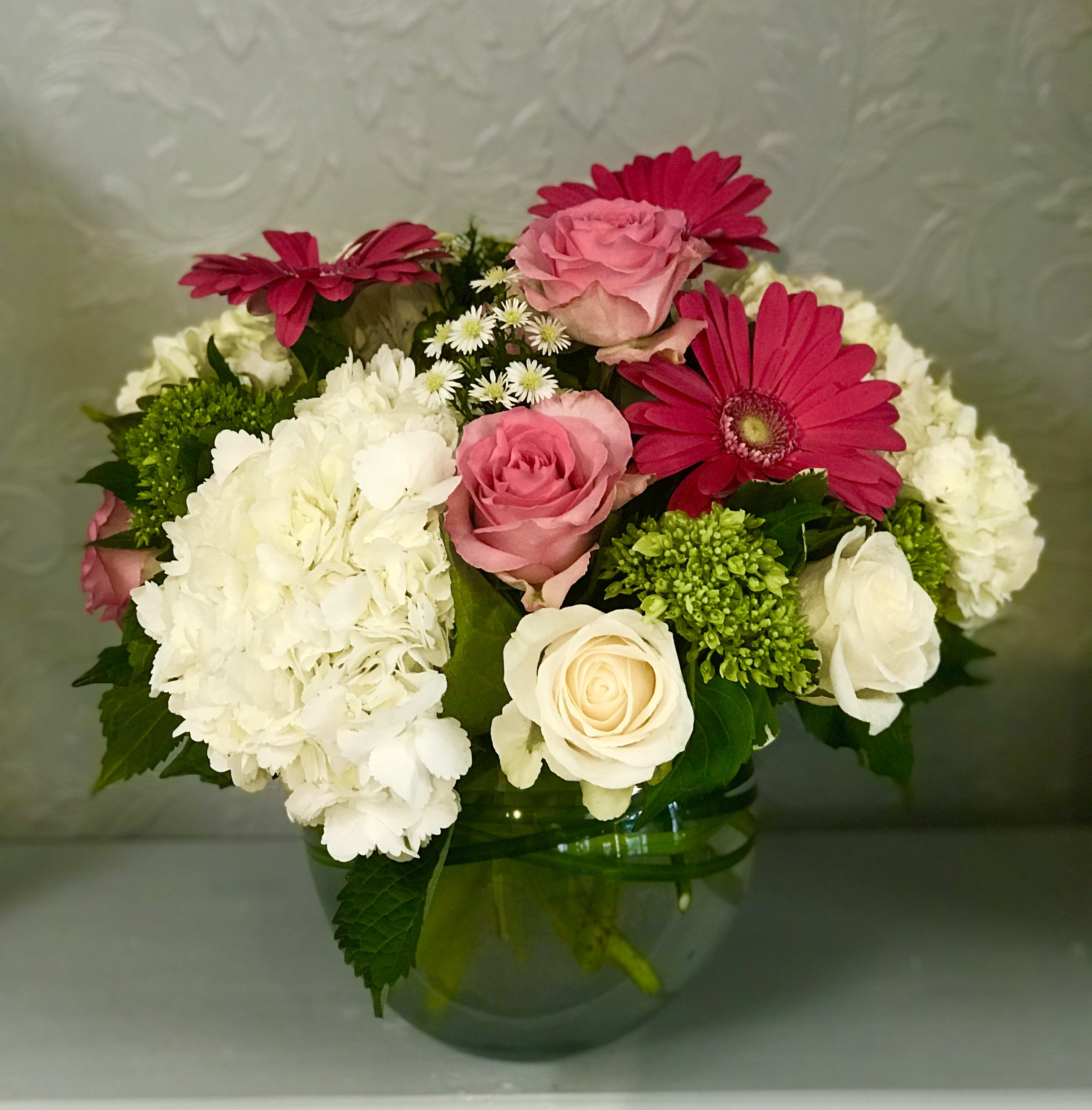 Hydrangea and Roses Delight - Premium white and green hydrangea, hot pink gerberas, and white vendela  and sweet unique pink roses arranged in a 8 inch bubble ball lined with lily grass. 