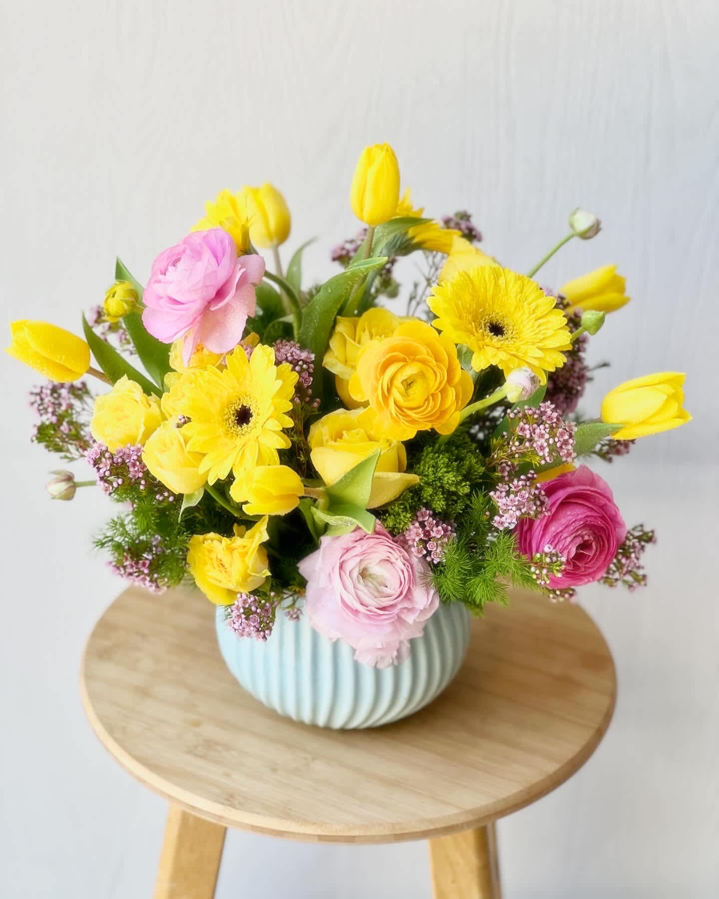EC103 Spring Harmony - Introducing our Spring Harmony arrangement! Bursting with the colors of spring, this charming arrangement features sunny yellow tulips, soft pink lisianthus, and delicate yellow roses in a beautiful blue ceramic vase. It's the perfect way to bring the freshness and joy of spring into any space. Brighten your day with this delightful ensemble!