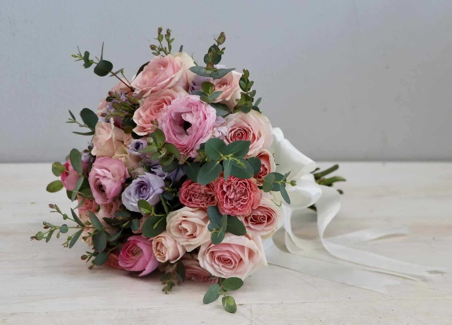 Meadows Bridal Bouquet - Boutique Collection - As the name suggests, this arrangement feels romantic and sweet. The pink roses are delicate and sweet, and the lavender and greenery add a touch of fragrant romance. FOR EVENTS DELIVERY: 7.5% OF EVENT SUBTOTAL DELIVERY + SETUP: 15% OF EVENT SUBTOTAL