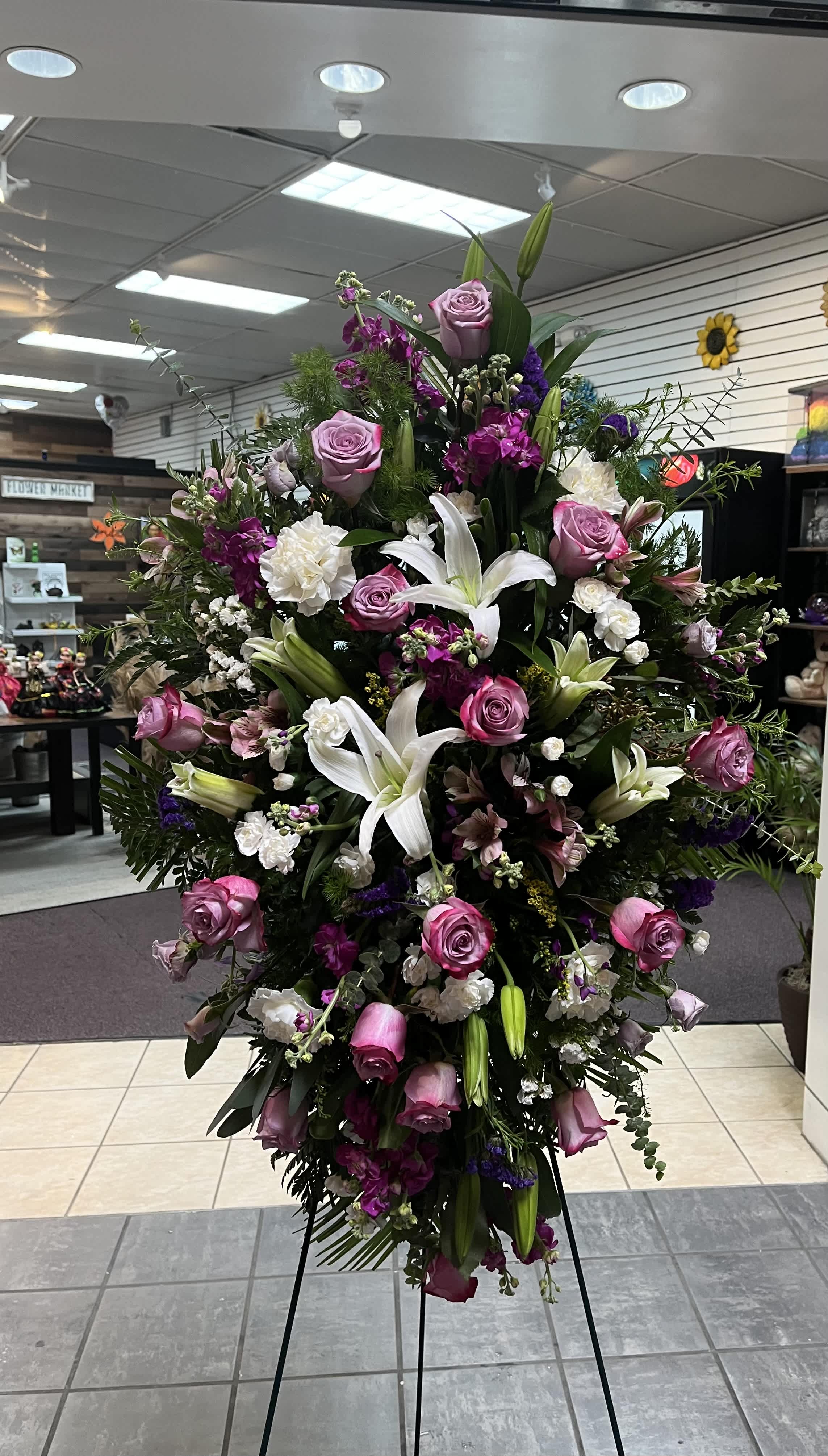Serenity Spray Serenity Spray - This dignified funeral arrangement features lavender roses, white lilies, and carnations, accented with mini roses, alstroemerias, and eucalyptus for a serene tribute.