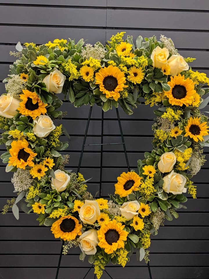 Graceful Goodbye Graceful Goodbye - The "Graceful Goodbye" arrangement pairs sunflowers and roses with variegated pittosporum and carnations for a warm and dignified farewell.