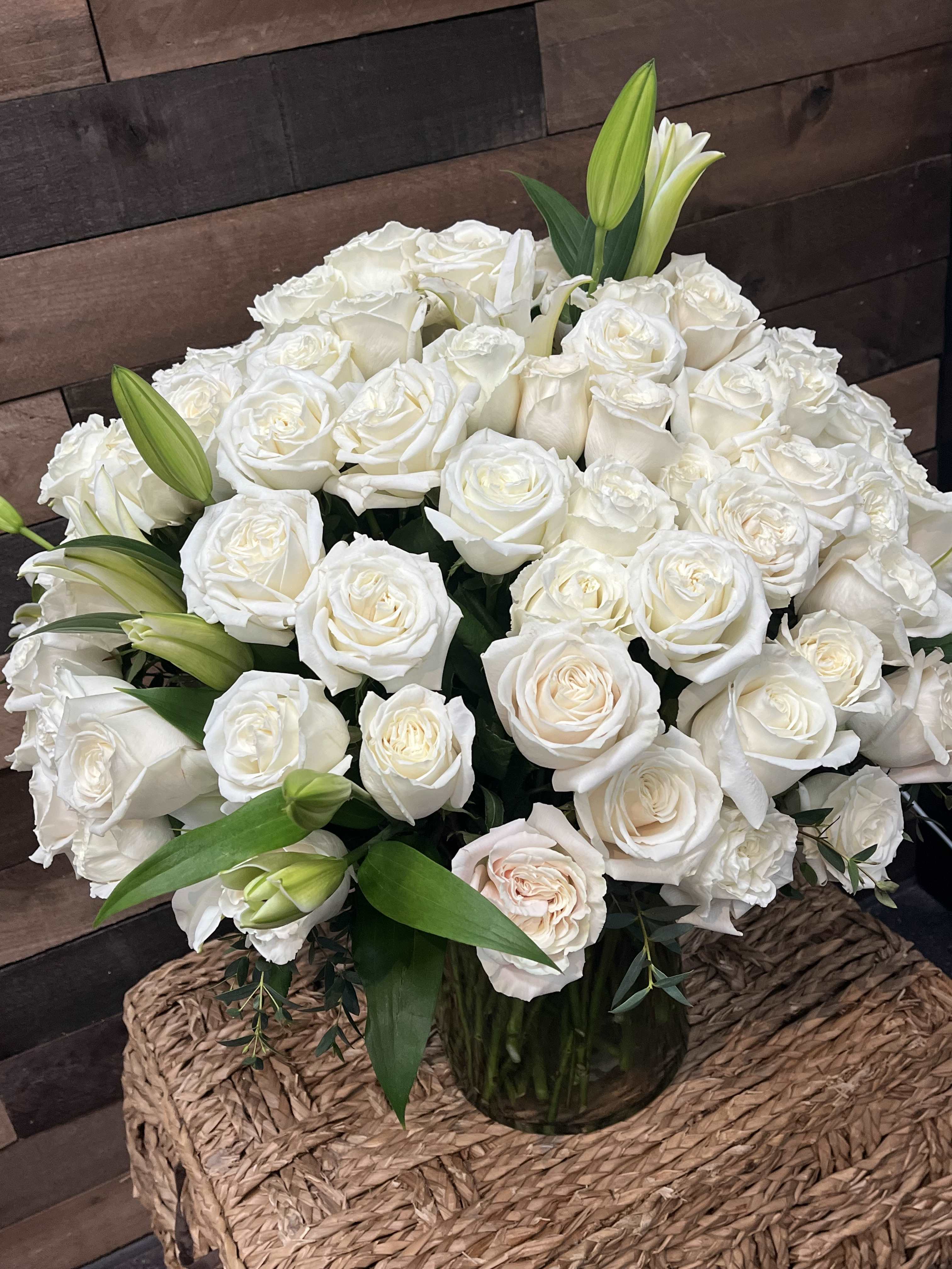 Devoted Heart Bouquet Devoted Heart Bouquet - The "Devoted Heart Bouquet" features 100 white roses and lilies, complemented by rich greenery, creating a breathtaking expression of pure devotion and love.