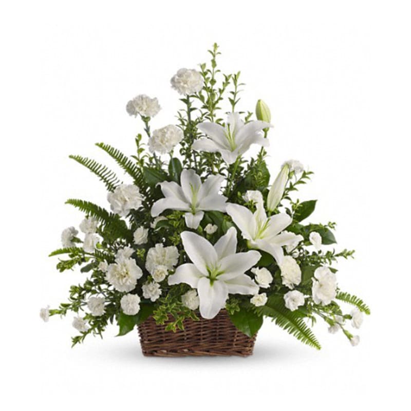 Peaceful White Lilies Basket - T228-1A: Whether you send this beautiful arrangement to the family home or to the service all will appreciate its elegance and grace. The contrast of brilliant white blossoms and dazzling greenery create a wonderfully calm and dignified setting.  Gorgeous flowers such as white lilies carnations and miniature carnations mix with vibrant greens in a large basket. Simply stunning.  Approximately 26&quot; W x 25&quot; H  Orientation: One-Sided  As Shown: T228-1A