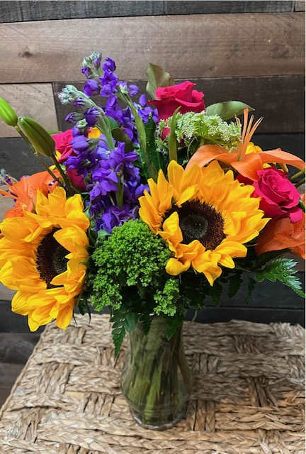 Sunny Romance Bouquet - The &quot;Sunny Romance Bouquet&quot; combines sunflowers, red roses, and orange lilies with alstroemerias and lush greenery, creating a vibrant and cheerful display full of warmth and affection.
