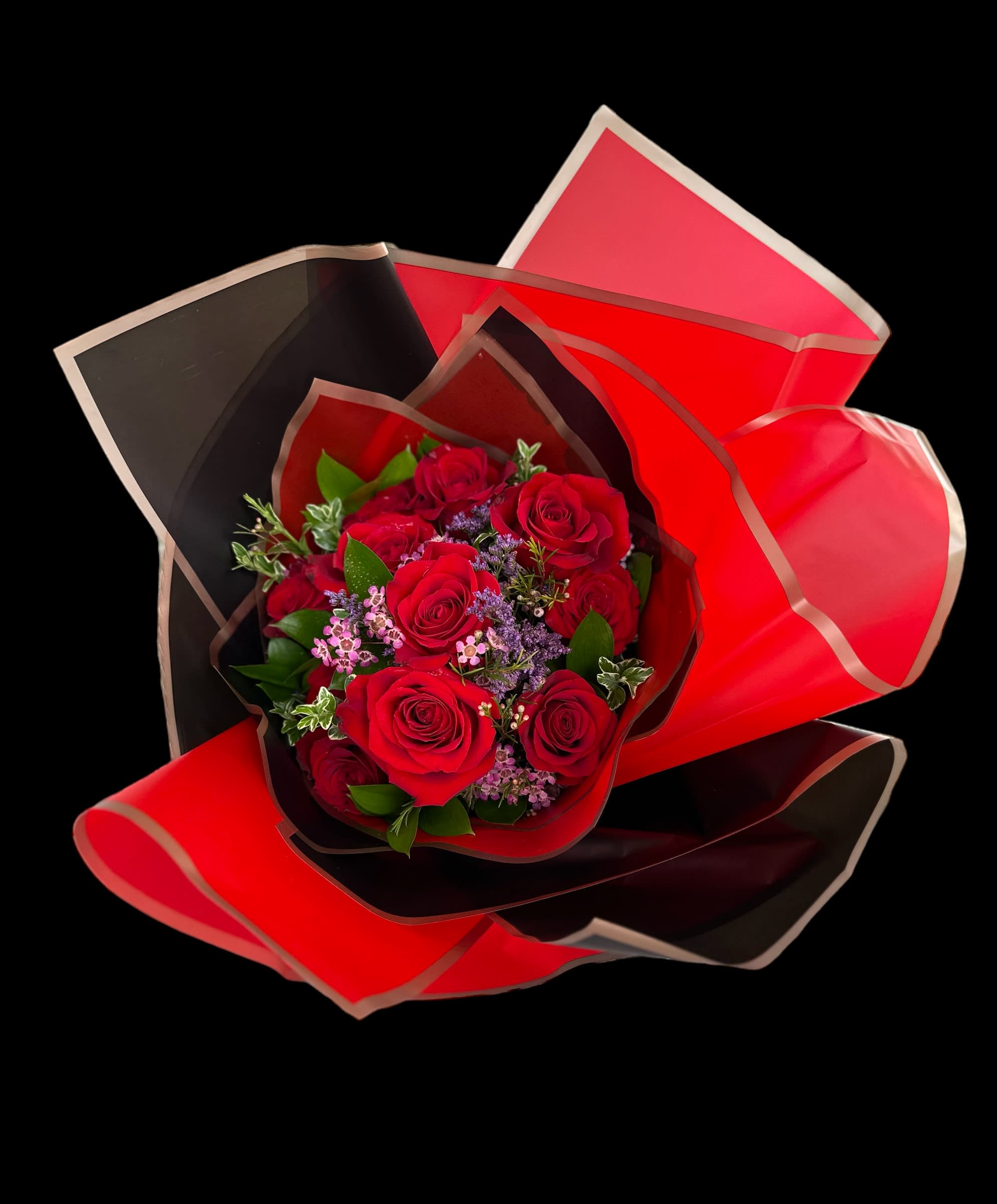 Chaney´s Red Romance 1001 - Romance is in the air with this stunning classic dozen of long stemmed red roses, with mixed greenery enhanced with a touch of hot pink wax flour in lavender Limonium. This is a wrapped bouquet.