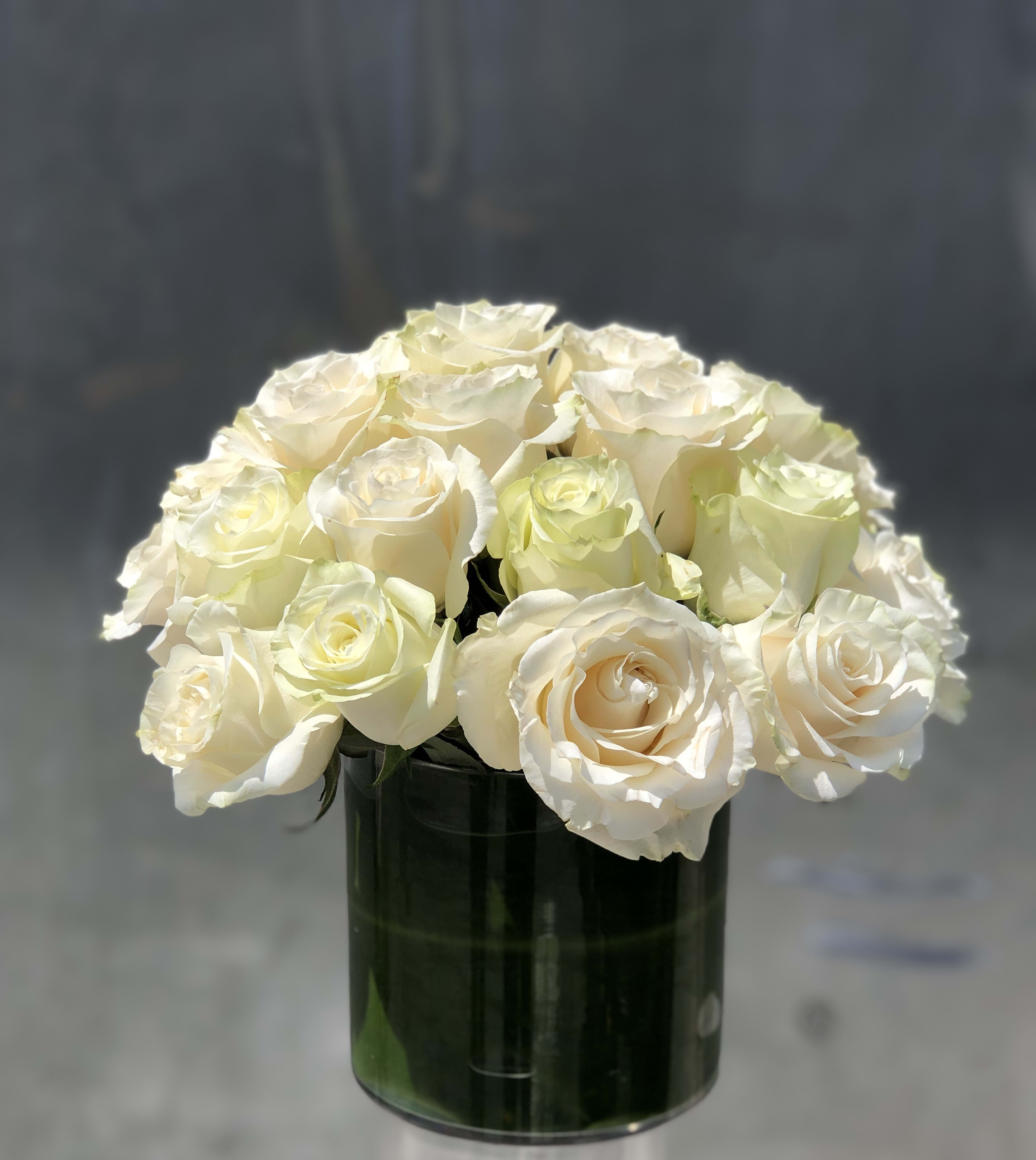 Peaceful Rose Peaceful Rose - All white roses in a glass vase filled with ti leaves.