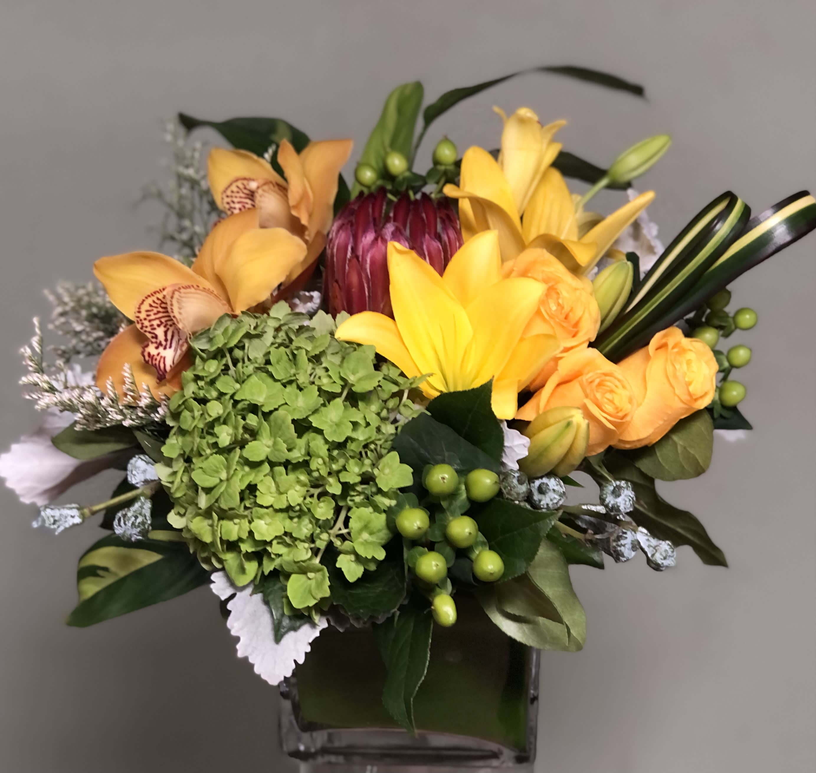 Shine and Bright Shine and Bright - Tiger Lily, protea, orchids, coffee bean, Hydrangea in glass vase