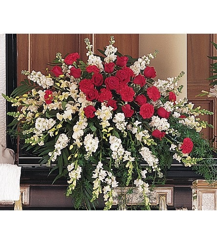 Cherished Moments Casket Spray Cherished Moments Casket Spray - Throughout the years there were many cherished moments. One half-couch casket spray features white stock snapdragons and dendrobium orchids with a center cluster of red roses and carnations.
