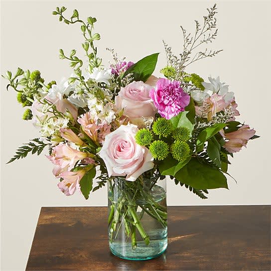 Happy Together - Our charming Happy together flower arrangement in a delicate glass vase is a beautiful ensemble of pink roses, pink alstroemeria, green button poms, and pink carnations. This delightful combination creates a harmonious display of soft colors and gentle textures, perfect for conveying love, appreciation, or simply brightening someone's day.  The arrangement features the classic beauty of pink roses, symbolizing love, gratitude, and admiration. Their velvety petals and sweet fragrance make them an iconic choice for expressing heartfelt emotions. Paired with the elegant pink alstroemeria, the arrangement gains an added touch of grace and sophistication. Alstroemeria is known for its longevity and delicate beauty, making it a lasting token of affection.  The playful green button poms add a lively element to the bouquet with their round, button-like blooms. These charming flowers bring a sense of joy and playfulness to the arrangement, while the pink carnations provide a touch of charm and nostalgia. Carnations symbolize admiration and fascination, making them a perfect addition to any sentimental gesture.  All the flowers are thoughtfully arranged in a clear glass vase, enhancing the beauty of each individual stem while showcasing the overall elegance of the arrangement. The transparency of the vase allows the colors and textures of the blooms to shine through, adding a touch of modernity to the ensemble.  This flower arrangement is versatile and suitable for various occasions, whether it's a birthday, anniversary, or simply a way to brighten someone's day. With same-day delivery available in Boca Raton, you can effortlessly bring joy and warmth to someone's life with our charming arrangement of pink roses, pink alstroemeria, green button poms, and pink carnations. 