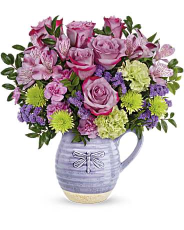 Teleflora's Whimsical Dragonfly - Pour on the love with this wonderfully whimsical gift! Bursting with a colorful bouquet, this glazed ceramic pitcher is as practical as it is charming--it's food-safe so they can enjoy it on their breakfast table for years to come!