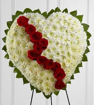 The FTD® Broken Heart™ - The FTD® Broken Heart™ is a beautiful way to express the impact that the departed had on your life. Pearly white chrysanthemums form the shape of a heart, accented with greens lined around the oustide and &quot;broken&quot; in the middle with a line of rich red roses to create an exquisite way to honor the life of the deceased at their memorial service. Displayed on a wire easel. Approximately 22&quot;H x 22&quot;W. Your purchase includes a complimentary personalized gift message.