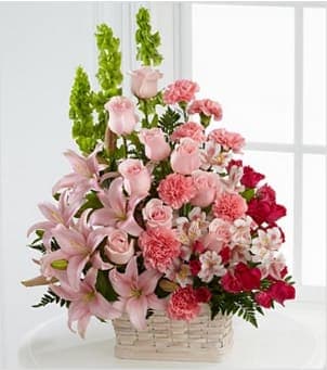 The FTD® Beautiful Spirit™ Arrangement - The FTD® Beautiful Spirit™ Arrangement is a light and lovely way to honor the life of the deceased. A blushing display of pink roses, Asiatic lilies and Peruvian lilies are highlighted by stems of fuchsia carnations and spray roses as well as Bells of Ireland and assorted lush greens. Seated in a white woodchip basket, this graceful arrangement creates an exceptional way to offer peace and sympathy.. Approximately 24&quot;H x 16&quot;W. BETTER bouquet includes 34 stems. Approximately 26&quot;H x 21&quot;W. Your purchase includes a complimentary personalized gift message.