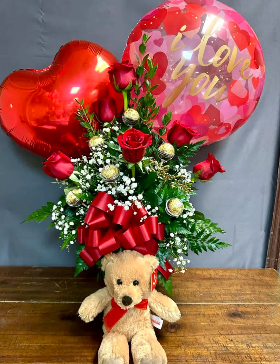 Half Dozen Red Rose Combo - Half Dozen Red Rose Arrangement in a clear vase. Arrangement comes with a bear plush and 2 mylar balloons and 6 Ferrero Rocher Chocolates.