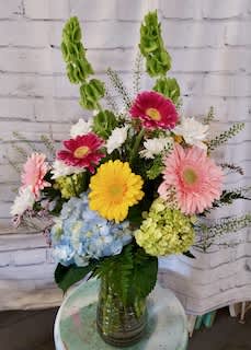 Just Bloomful Just Bloomful - Say "Happy Mother's Day" with this bloomful bouquet! Beautiful gerber daisies in muted colors of the rainbow accesnted with hydrangea, daisies and Bells of Ireland.