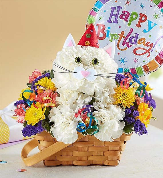 PURR-FECT PARTY CAT - Every birthday party needs a party animal…especially one as cute as ours! Our truly original kitty is handcrafted from crisp white carnations and surrounded by a mix of colorful blooms, creating a unique 3D design. Arriving inside a charming handled basket and ready to celebrate—accented with a party hat and colorful curling ribbon—this whimsical whiskered pal is the “purr-fect” pick for wishing someone special a day full of fun…no matter what age they’re turning!  