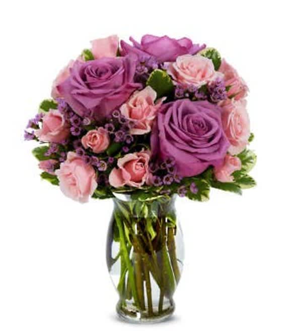 SPECIAL MOMENTS BOUQUET - Our Special Moments Bouquet is perfect for any person and for any special occasion. Its perfect purples and pretty pinks speak for themselves as they famously continue to symbolize love, care and compassion. This bouquet is the perfect classic-meets-modern floral arrangement. Furthermore, we guarantee that your recipient will love it as a birthday gift, congratulations gesture, anniversary and more!  Includes: • Purple Roses • Pink Spray Roses • Pink Waxflowers • Seasonal Greens • Glass Vase  