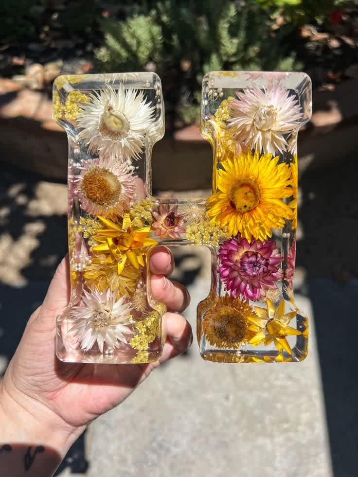 Alphabet Letter Preserved Bouquet Block, Dried Flower 3D Letter Block, Bridal Bouquet Preservation, Wedding Gift - Alphabet Letter Preserved Bouquet Block, Dried Flower 3D Letter Block, Bridal Bouquet Preservation, Wedding Gift Item details Handmade Materials: Epoxy Resin, real dried flowers Turn your special flowers into works of art that lasts a lifetime! Our team of experts can transform your flowers into letter bouquet blocks. Our letter bouquet blocks offer an innovative way to reminisce on special memories in your life while adding a personal touch to your home decor. Letter bouquet blocks are a beautiful way to personalize your preservation. Each letter bouquet block is personalized to your vision for your flowers, and we provide a detailed journey for your flowers along the preservation process. Our team provides updates for each step of the process and will send you mock up photos of your design for your approval. It is our honor to preserve your flowers and we take pride in our meticulous and efficient artistry.  Measurements: 6” in height Shapes: A - Z lettering and Ampersand (&amp;)  Note: The letter P does not stand on its own. The letter P will need a prop or we can install an alligator clip for wall hanging.  Personalization: Adding inlaid objects requires a $60 personalization fee.  Make Time &amp; Drying Process: Each piece is a one of a kind made from pressed flowers. In our Letter Bouquet Blocks we use whole preserved flowers and stems to create a 3-D effect. Letter blocks require 3 to 4 months because of this process to be made. Flower preservation is an extensive process with many steps that must be done in a time frame that is subjective to the specific flower’s attributes. Our make time begins from the moment we receive your flowers in the mail and return shipped to you. Please keep in mind that all flowers have their own unique dry times and personalities in resin.  Bubbles &amp; Color Change: Please be aware we cannot control bubbles or imperfections that appear in the resin after the preservation is completed. We do our absolute best to mitigate any defects that may occur but, we gently remind you that each piece is a handcrafted work of art. Variations in resin and look may differ from one piece to the next. Flowers will change color in the preservation process. This is a very natural occurrence as the flower’s quality and texture will change in the drying process. Flowers become more brittle and the hue tends to fade. For example, orange flowers may turn yellow or white flowers can become off white or yellowed.  White calla lilies and lisianthus flowers will turn yellow. Some flowers like hydrangea, orchids and roses will show translucent spots once placed in resin.  Instructions of Care: We urge you to take special care of your preservation to ensure longevity of the piece. We recommend all resin item are displayed out of direct or indirect sunlight, and in a cool air conditioned environment. Resin can become malleable or yellow in heat regardless of its quality or brand.  