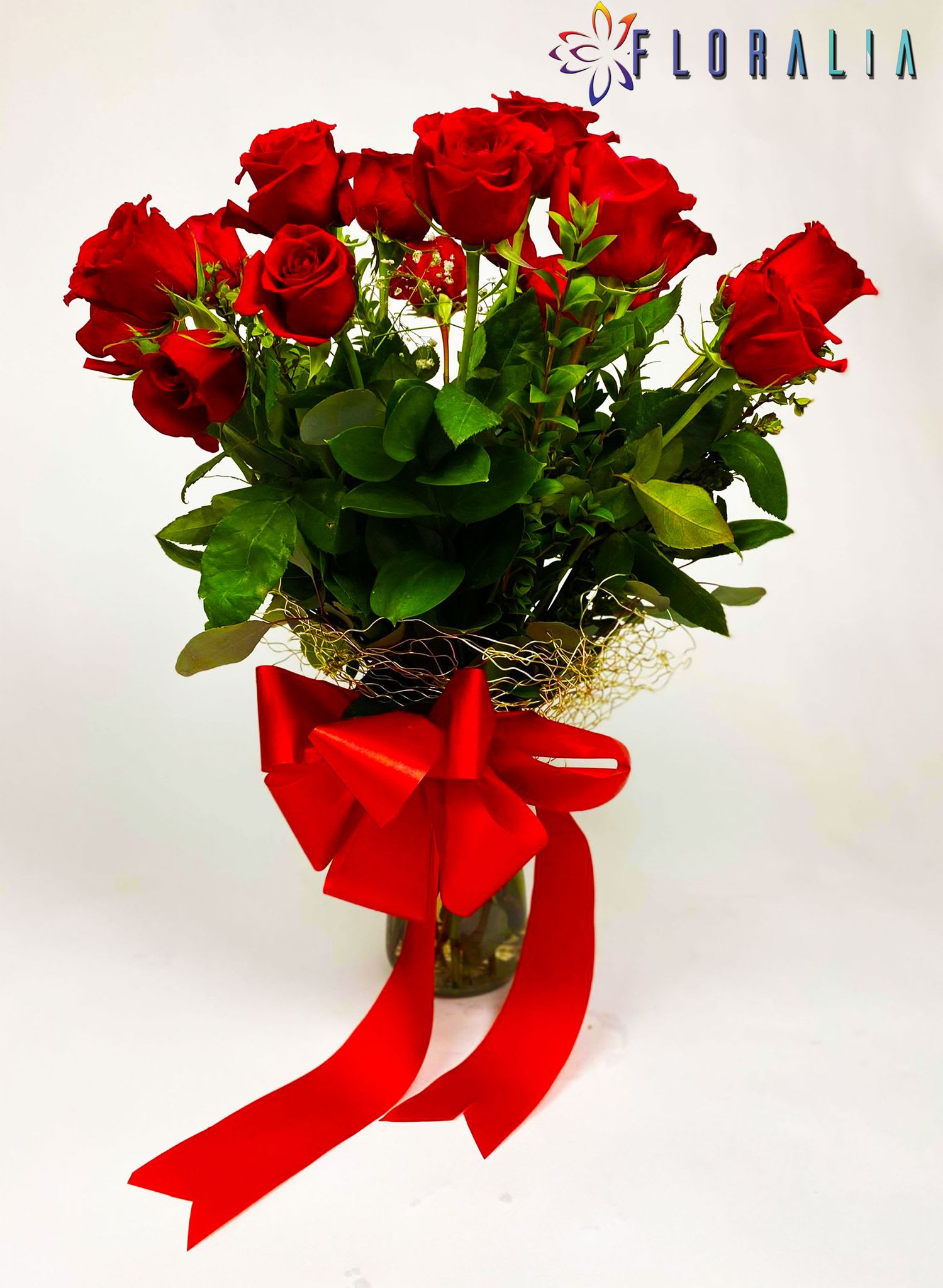 Melody - Twenty-four red roses in their own foliage, highlighted by the green of the eucaliptos, inside a glass vase, embraced by a metallic mesh and a beautiful bow.