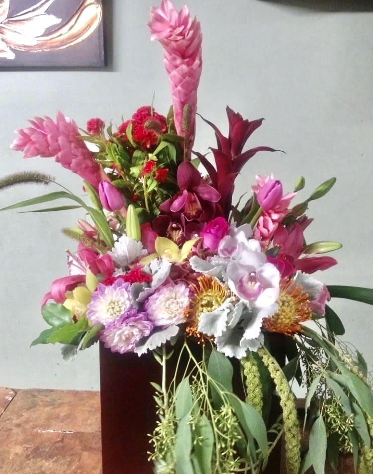 Tropic Bloom Tropic Bloom - Variety of tropical flowers beautifully put together in a tall glass vase.