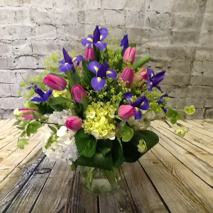 Spring favorites - A perky assortment of imported Dutch tulips and iris springing from a bed of white and green hydrangea