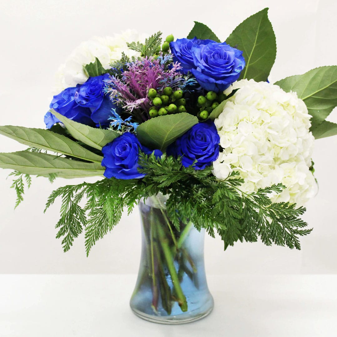 Electric Charm (NEW ITEM) - This creative masterpiece features our tinted blue roses and hydrangeas!  Perfect for any occasion.  Perfect for a desk, end table, small coffee or dining table!  Just beautiful!!